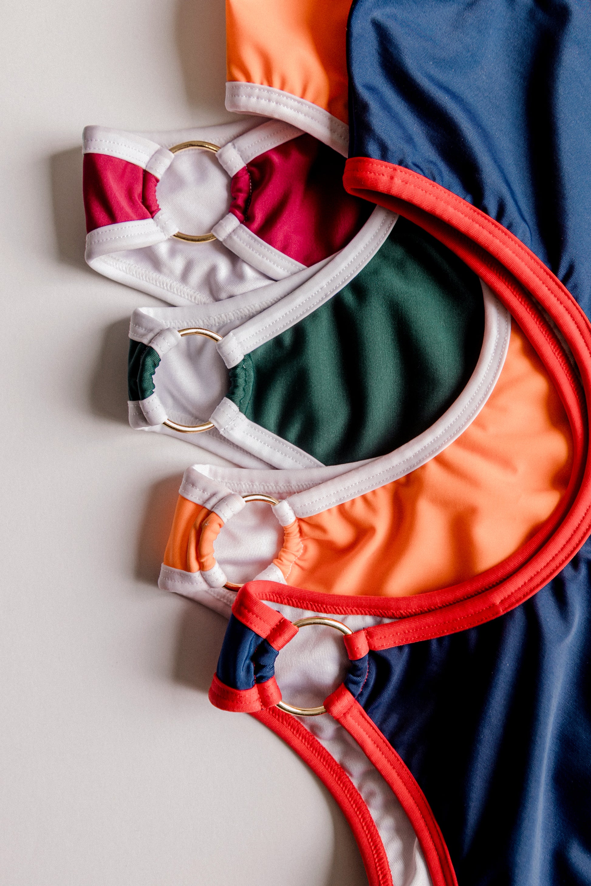 Boomerang one-piece swimsuit collection, multiple colors flatlay – Bikini Uni