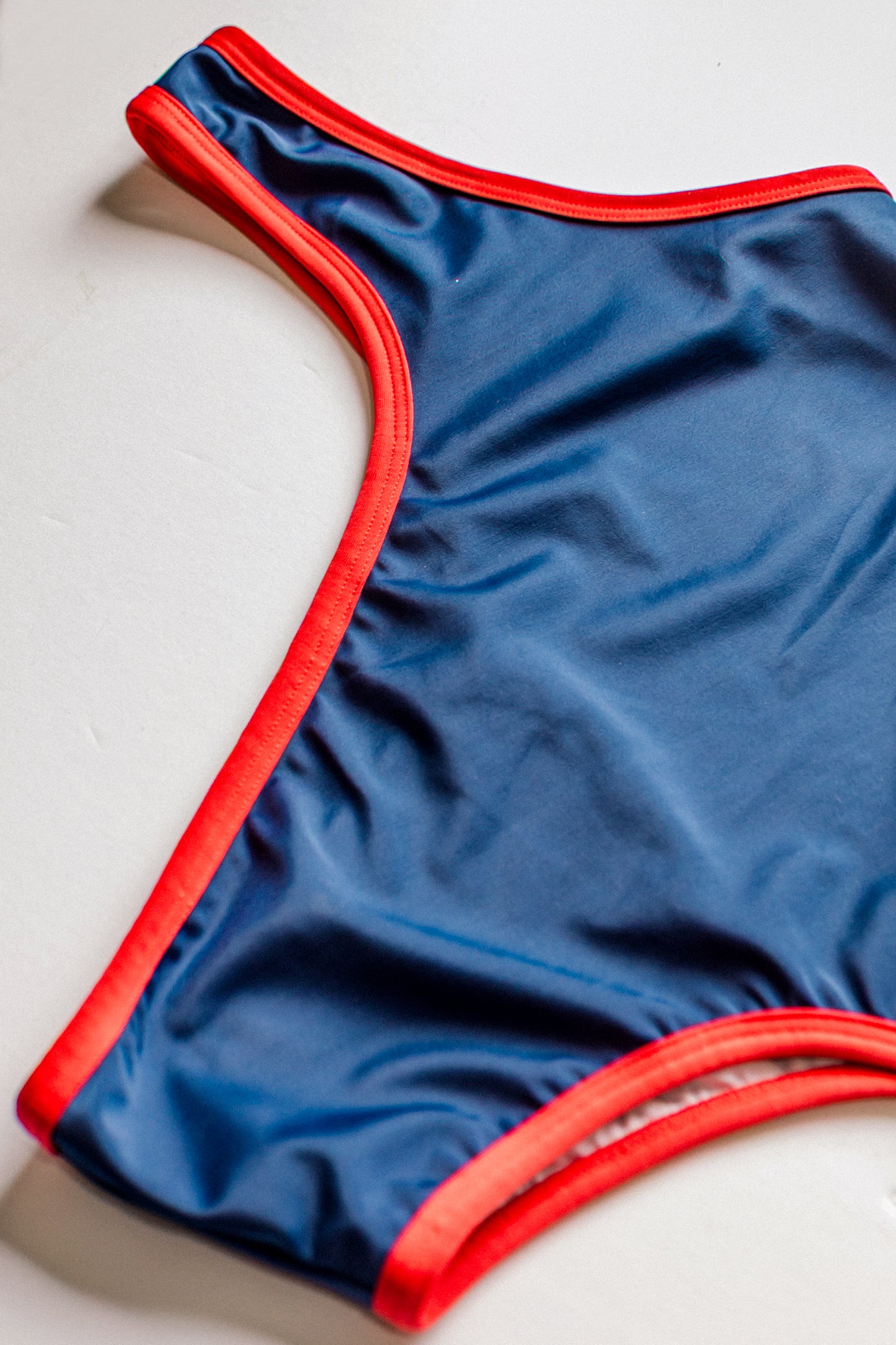 Boomerang one-piece swimsuit in navy with red, detail view – Bikini Uni