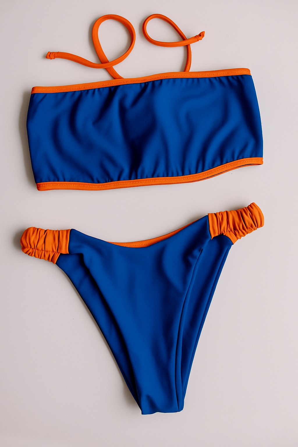 Dos Tierras two-piece bikini in blue with orange, front flatlay view – Bikini Uni