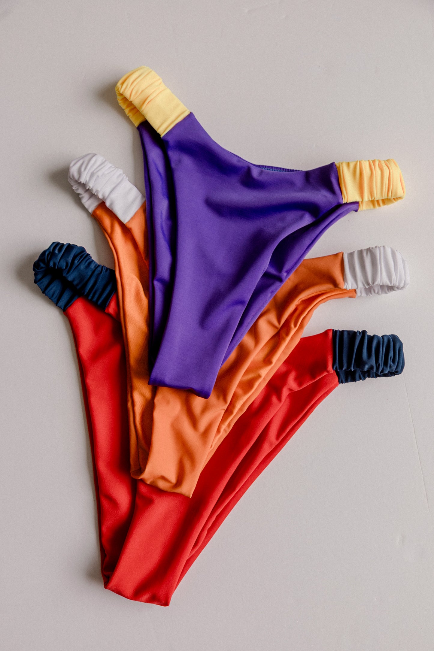 Dos Tierras bikini bottoms in multiple colors, all variants flatlay – Bikini Uni