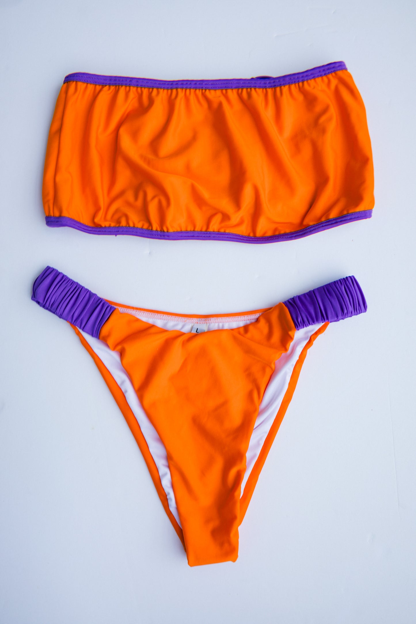Dos Tierras two-piece bikini in orange with purple, back flatlay view – Bikini Uni