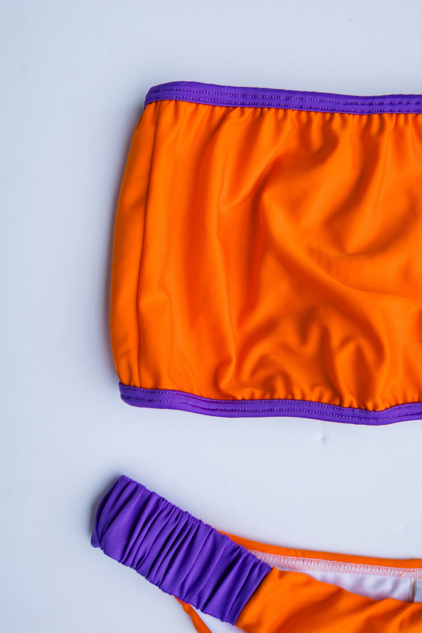 Dos Tierras bikini in orange with purple, fabric detail close-up – Bikini Uni