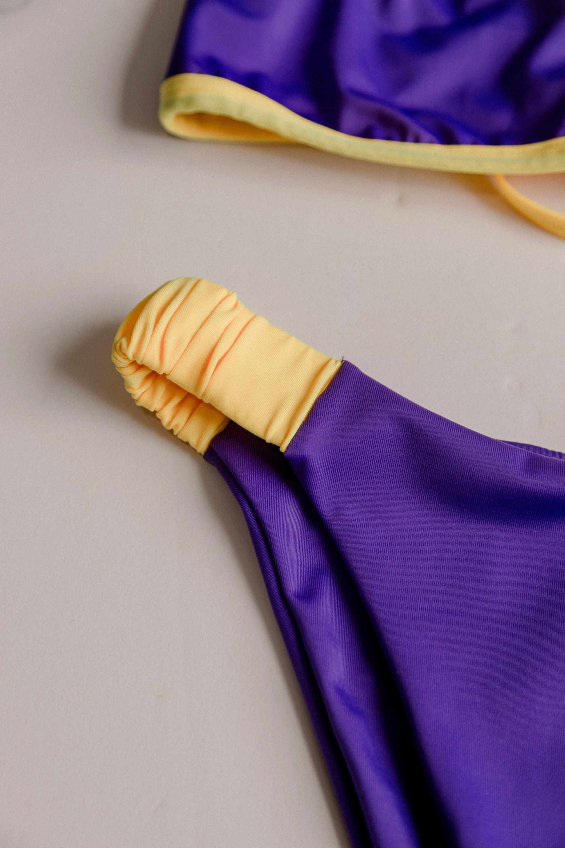 Dos Tierras two-piece bikini in purple with gold, fabric detail close-up – Bikini Uni