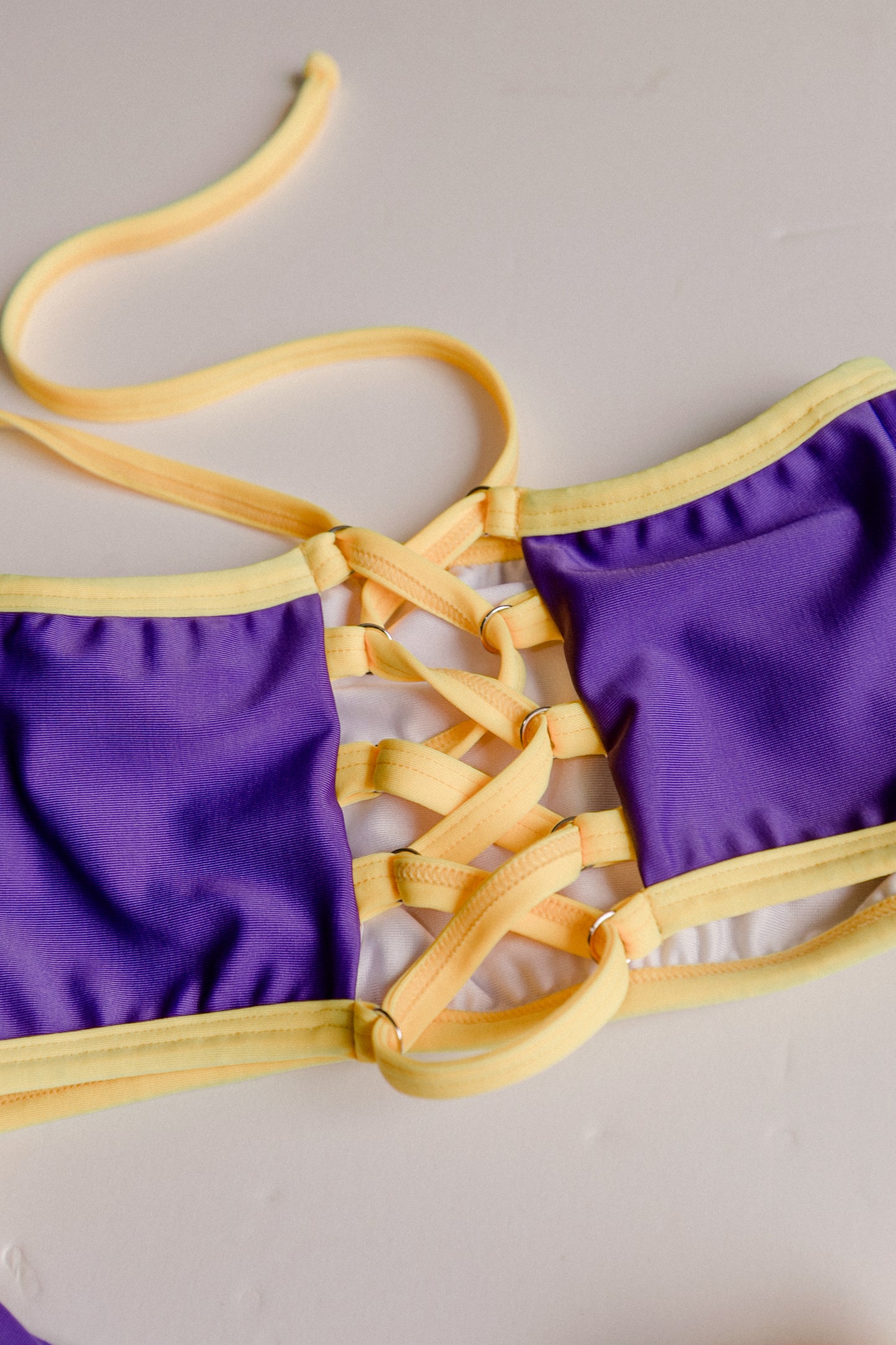 Dos Tierras two-piece bikini in purple with gold, lace-up detail close-up – Bikini Uni