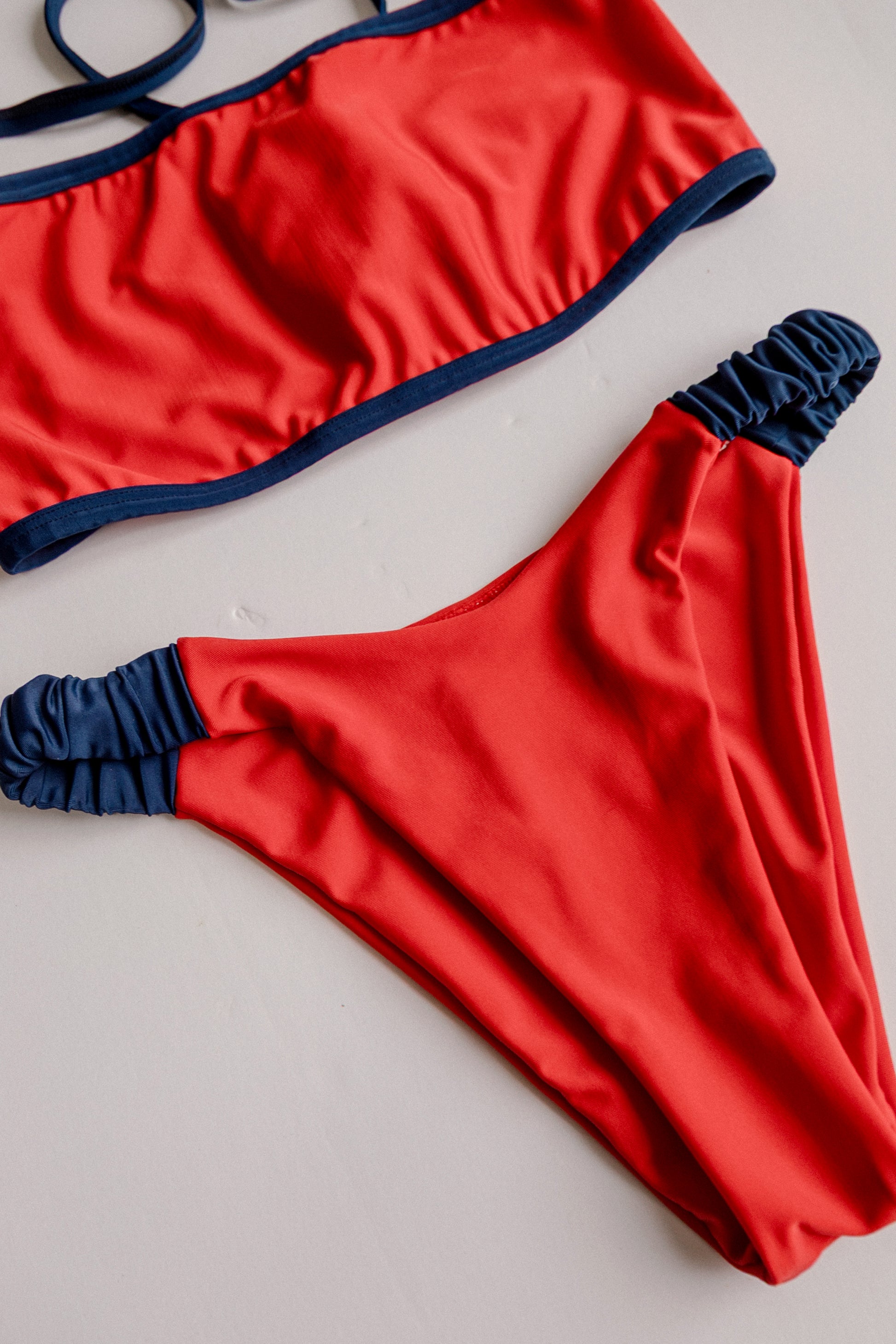 Dos Tierras two-piece bikini in red with navy, front flatlay view – Bikini Uni
